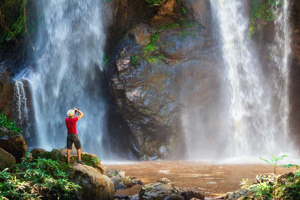 backpacker enjoying a tropical waterfall