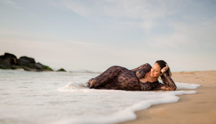 Beach Maternity Photo Pregnant woman laying in the sand and waves