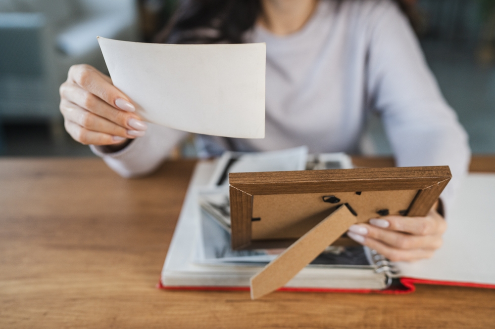 close up of woman look at photos in picture frame