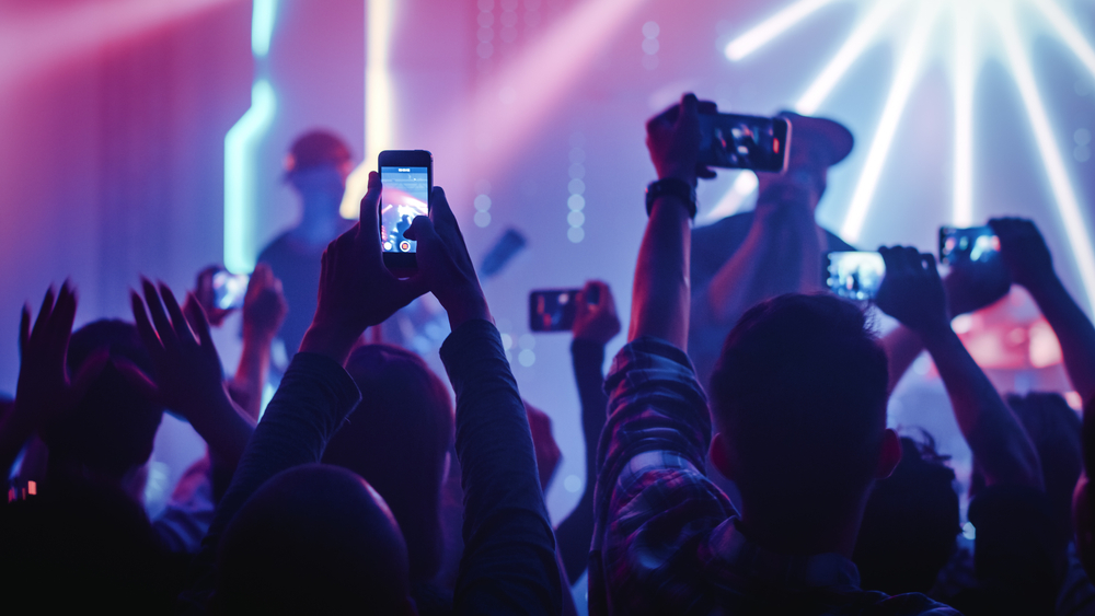 crowd holding up smartphones at a concert